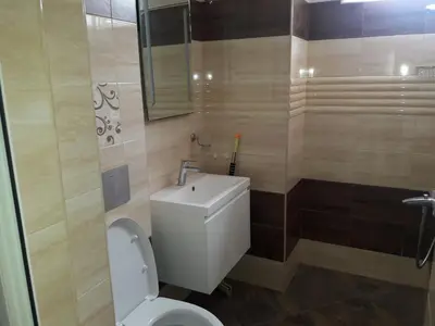 a bathroom with a white toilet and a sink at Guest House Mania in Sofia