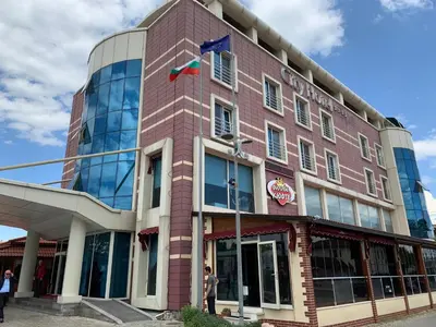 a red brick building with a flag on it at City Hotel Plovdiv FREE PARKING in Plovdiv