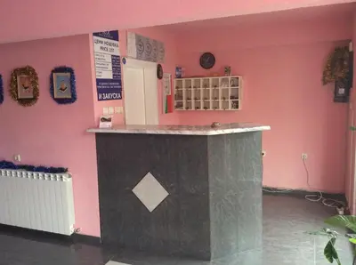 a bar in a room with a pink wall at Hotel Balevurov in Sandanski