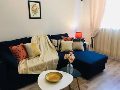 a living room with a blue couch and a table at Urban Garden in Sofia