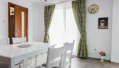 a dining room with a white table and chairs at Apartments Nasini by Flat Mаnager in Plovdiv