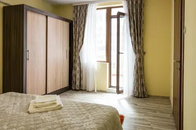 a bedroom with a bed and a large window at Apartments Nasini by Flat Mаnager in Plovdiv