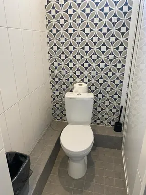 a bathroom with a toilet and a tile wall at Bla Bla Hostel in Sofia
