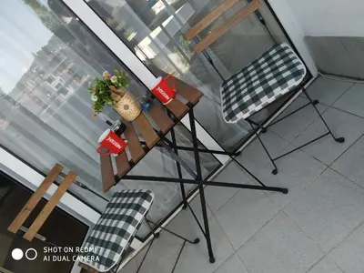 a table and two chairs in front of a window at Апартамент за нощувки in Gotse Delchev
