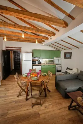 a kitchen and living room with a table and a couch at Пе́трови Вили in Ribarica