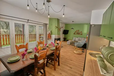 a dining room and living room with a table and chairs at Пе́трови Вили in Ribarica