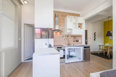 a kitchen with white appliances and a dining room at blueWaveplace - Contemporary Home in Center of Sofia in Sofia