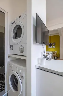a laundry room with a washing machine and a tv at blueWaveplace - Contemporary Home in Center of Sofia in Sofia