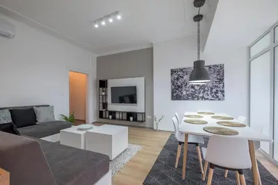 a living room with a couch and a table and chairs at blueWaveplace - Stylish 2 BR Home in Center of Sofia in Sofia