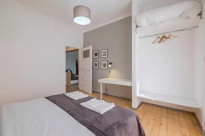a white bedroom with a bed and a desk at blueWaveplace - Stylish 2 BR Home in Center of Sofia in Sofia