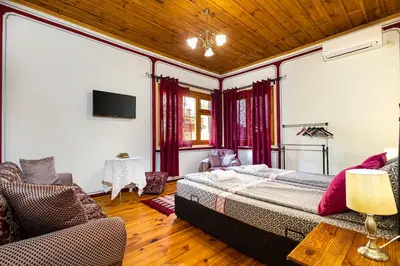 a bedroom with a bed and a couch and a tv at Blacksmith's House - Old Town in Plovdiv