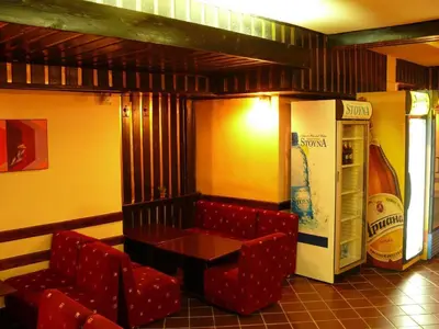 a restaurant with red chairs and a table and a soda machine at Почивна станция Витоша in Velingrad