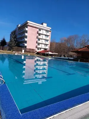 a large swimming pool with a building in the background at Почивна станция Витоша in Velingrad