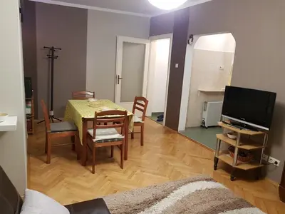 a living room with a table and chairs and a television at Artistic studio in Sofia's top center in Sofia