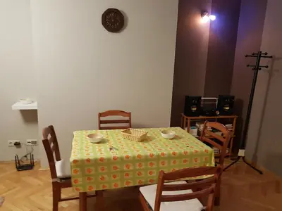 a dining room with a table and chairs and a clock on the wall at Artistic studio in Sofia's top center in Sofia