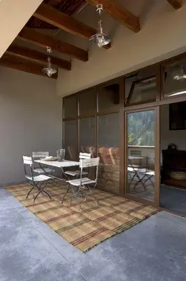 a dining room with a table and chairs on a rug at The Reddoorshouse in Solishta