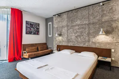 a bedroom with a large bed and a red curtain at Art Hotel Simona in Sofia