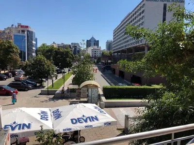 a djinn umbrella sitting on a sidewalk in a city at ФЛАМА РЕЗИДЕНТС in Plovdiv
