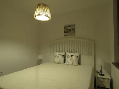 a bedroom with a white bed and a chandelier at Willy Villy's Home- Chepelare in Chepelare