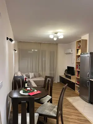 a living room with a dining room table and a kitchen at Kamy-Sophia Apartment in Sofia