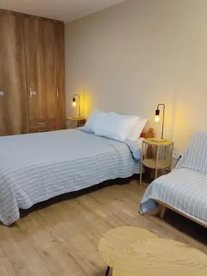 a hotel room with two beds and a chair at Kamy-Sophia Apartment in Sofia