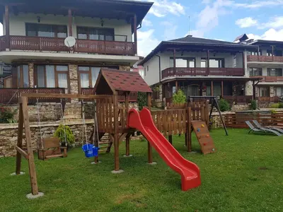 a playground in front of a house with a slide at Къщи за гости БАШЕВИ in Sarnitsa