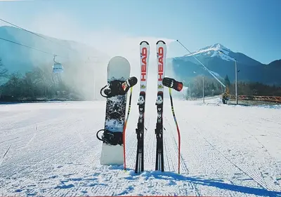 two snowboards and skis are standing in the snow at Family 2 bed Apartment in Bansko in Bansko