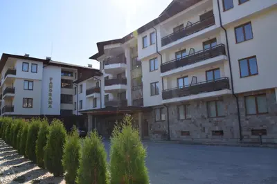 a row of apartment buildings with trees in front of them at Panorama Stoykite Yana apartment in Pamporovo