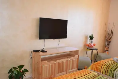 a living room with a television on a wall at Panorama Stoykite Yana apartment in Pamporovo