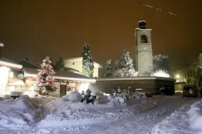 a church with a clock tower in the snow at Cozy Apartment Next to Gondola in Bansko