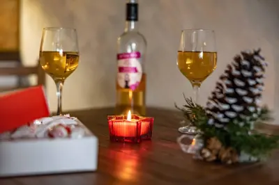 two glasses of wine and a candle on a table at Bansko home with a Mountain view in Bansko