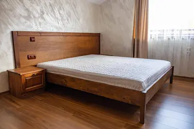 a bed in a bedroom with a wooden headboard at Bansko home with a Mountain view in Bansko