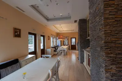 a kitchen and dining room with a stone wall at Къща за гости Пилигрим in Skrino