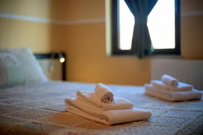 a pile of towels sitting on top of a bed at Къща за гости Пилигрим in Skrino