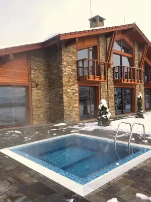 a large swimming pool in front of a house at Luxury Chalet & Spa Tia Maria with Private SPA in Bansko