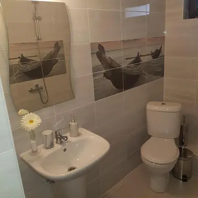 a bathroom with a sink and a toilet and a mirror at Guest House Ileana in Sapareva Banya