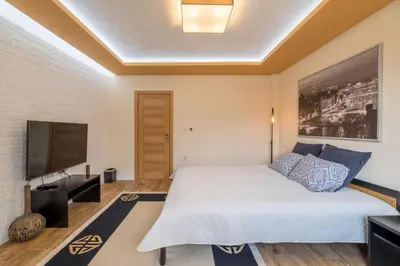 a bedroom with a bed and a flat screen tv at Villa ADELHEIDE - Spa, BBQ & Jacuzzi in Beli Iskar