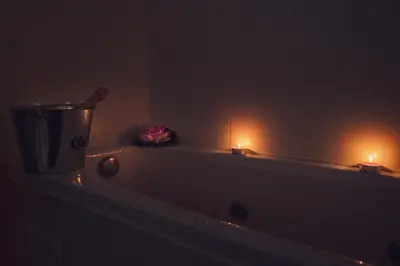 a bath tub with two candles and a bottle on it at Sky Garden House in Velingrad