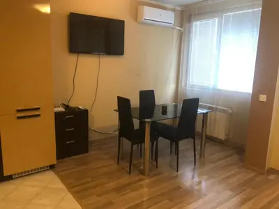 a dining room with a table and chairs and a television at Rakovski Apartment GN / FREE GARAGE in Sofia