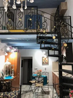 a spiral staircase in a living room with a table and chairs at Cosy House in Sofia