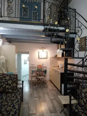 a living room with a spiral staircase and a table at Cosy House in Sofia