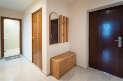 a dressing room with a wooden cabinet and a door at Апартамент АВА in Sandanski