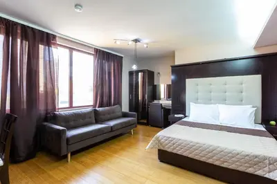a bedroom with a bed and a couch at CityHome Aparthotel in Sofia