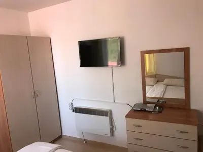 a bedroom with a mirror and a radiator and a bed at Apartment Lucy in Pamporovo