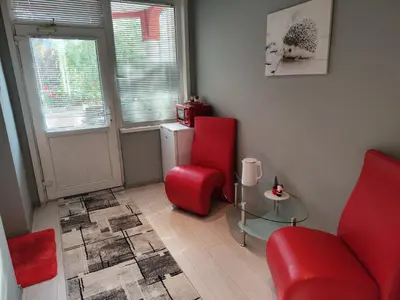 a living room with two red chairs and a table at Стаи за гости Ве-Бо-Ли** in Bankya
