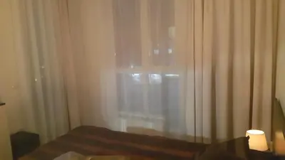 a bedroom with a bed and a window with curtains at Koko's apartments in Bansko