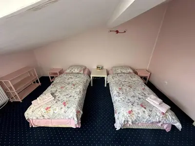 a room with two beds and a table in it at Cosy, quiet house with Vitosha view near Paradise in Sofia