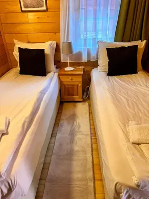 two beds in a room with a window at Alpine ski chalet Borovets with sauna in Borovets