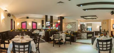 a restaurant with tables and chairs and a bar at Hotel Domaine Peshtera in Peshtera