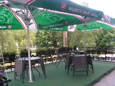 a group of tables and chairs under an umbrella at Семеен хотел Калина Family hotel Kalina Говедарци in Govedartsi